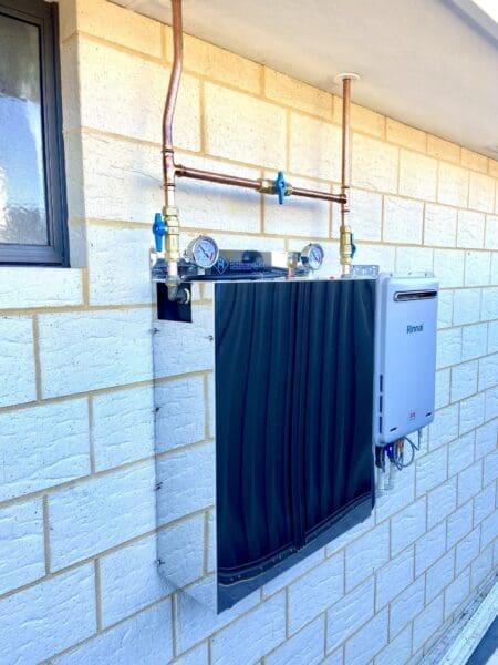 An Entrie Home Filtration System installed on brick wall with copper piping