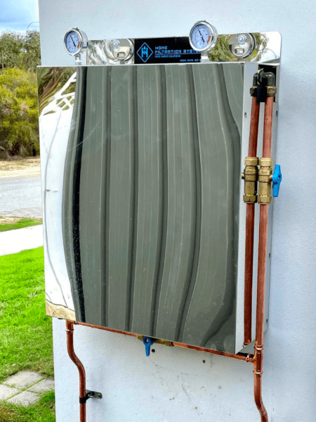 An Standard Home Filtration System installed on wall with copper piping